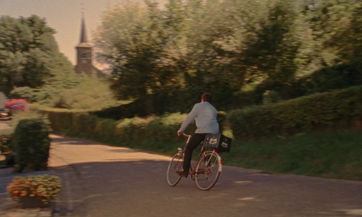 Meneer met een krat brand achterop zijn fiets